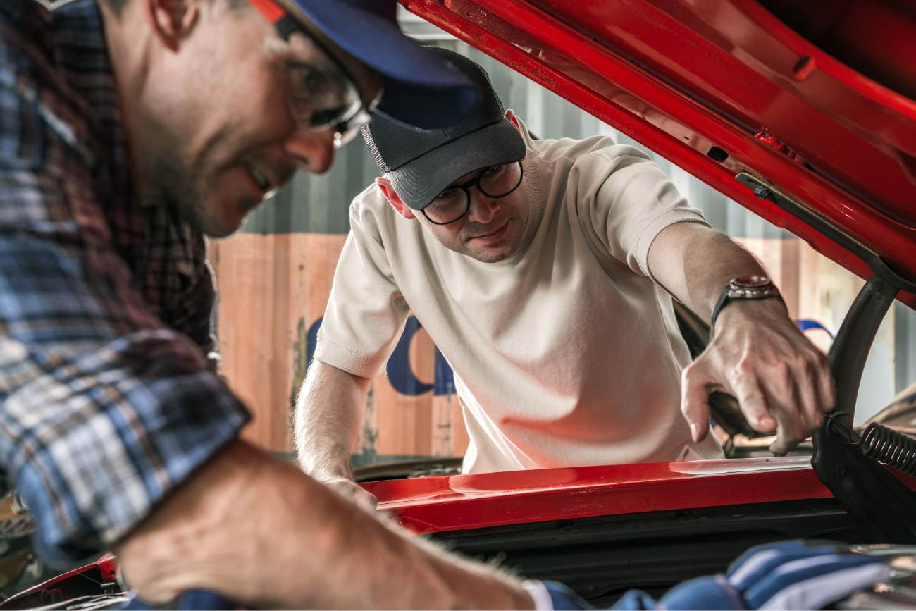 Équipe passionnée d'automobile travaillant sur des véhicules dans un garage moderne